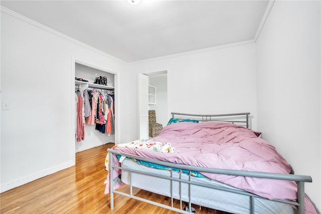 bedroom featuring ornamental molding, hardwood / wood-style floors, and a closet