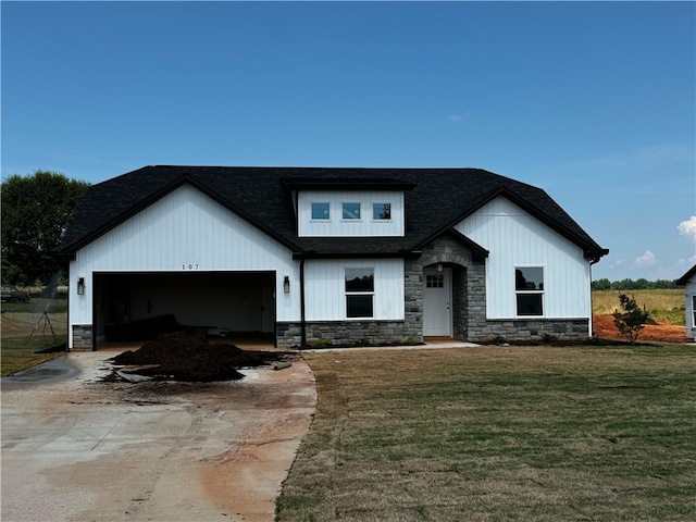 modern inspired farmhouse featuring a garage and a front lawn