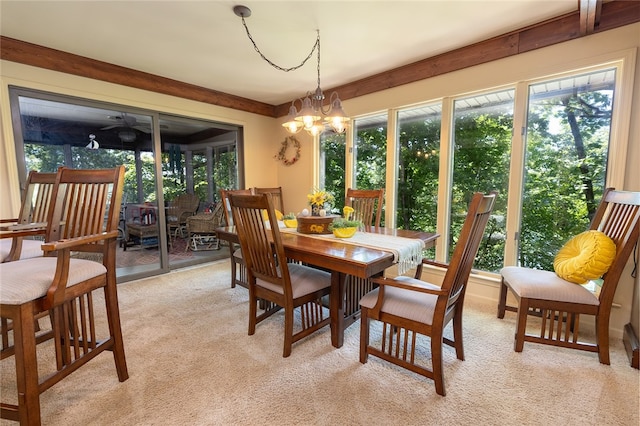 dining space featuring light carpet and a chandelier