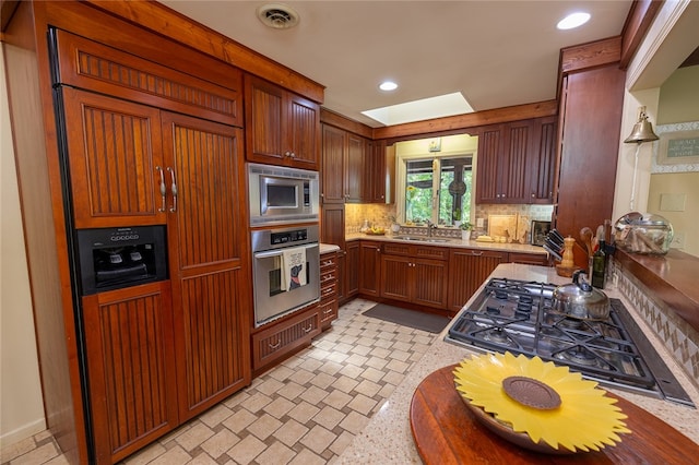 kitchen with decorative backsplash, sink, and stainless steel appliances