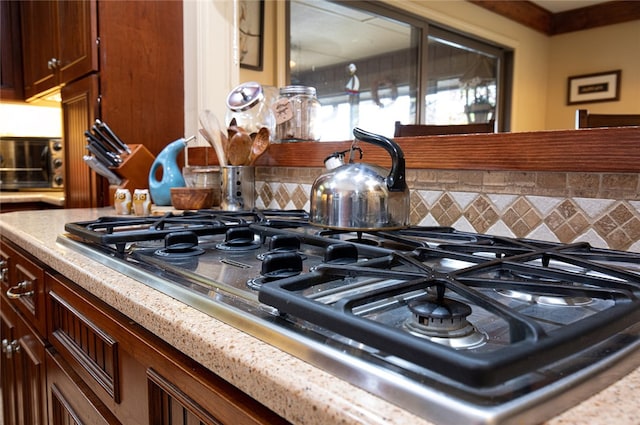 interior details with backsplash and stainless steel gas cooktop