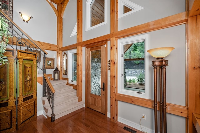 foyer with dark hardwood / wood-style flooring and high vaulted ceiling