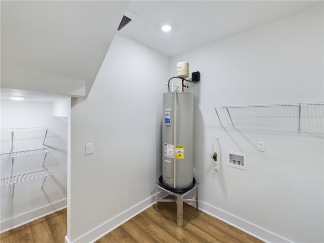 laundry room with dark hardwood / wood-style floors, electric water heater, and hookup for a washing machine