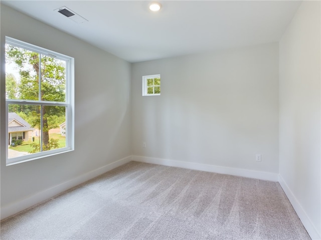 carpeted empty room featuring plenty of natural light