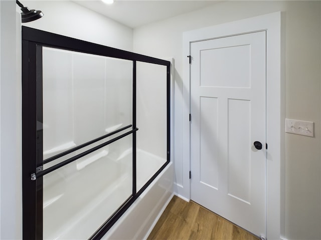 bathroom with enclosed tub / shower combo and hardwood / wood-style flooring