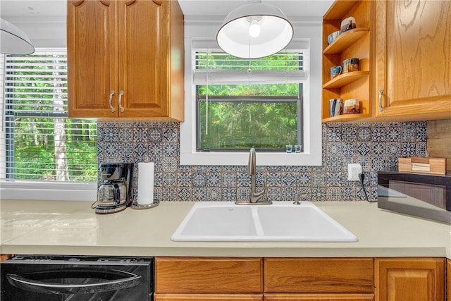 kitchen featuring decorative backsplash, dishwasher, and sink