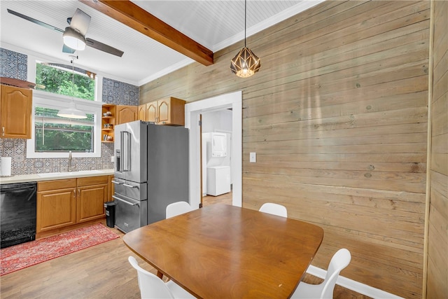 dining space featuring light wood-type flooring, beamed ceiling, sink, wooden walls, and ceiling fan