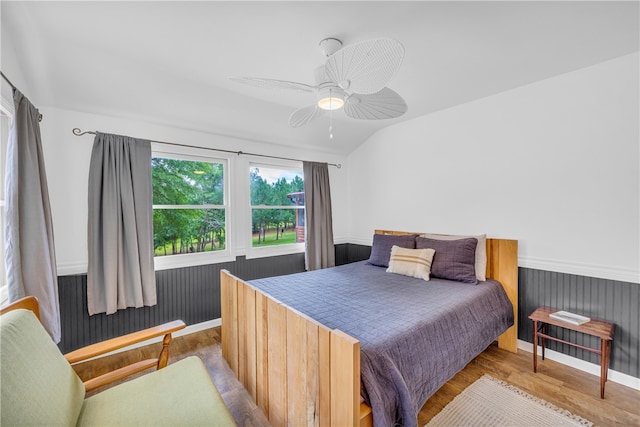 bedroom featuring light wood-type flooring, vaulted ceiling, and ceiling fan