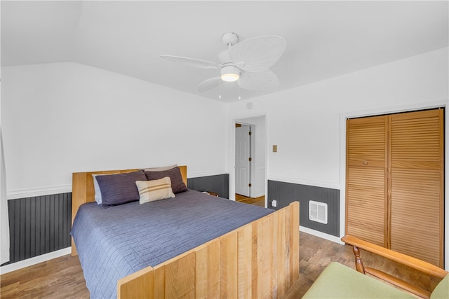 bedroom with lofted ceiling, dark wood-type flooring, ceiling fan, and a closet