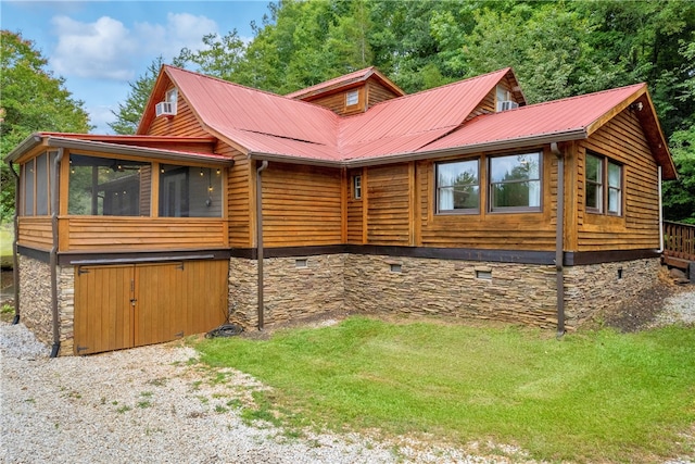 view of home's exterior with a lawn and a sunroom