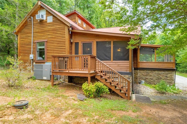 rear view of property with a sunroom and central AC