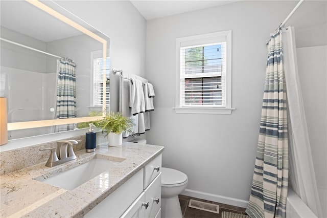 bathroom featuring toilet, vanity, and a shower with curtain