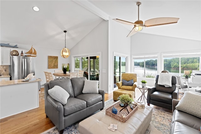 living room featuring vaulted ceiling, ceiling fan, and light hardwood / wood-style floors