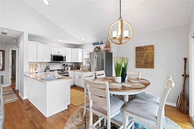 kitchen featuring tasteful backsplash, kitchen peninsula, sink, white cabinetry, and appliances with stainless steel finishes