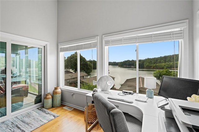 sunroom / solarium featuring a wealth of natural light and a water view