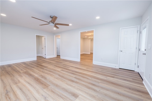 unfurnished bedroom with ceiling fan with notable chandelier and light hardwood / wood-style floors