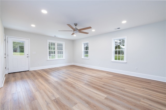 empty room featuring light hardwood / wood-style flooring, a wealth of natural light, and ceiling fan