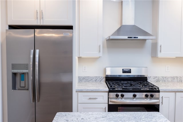 kitchen featuring wall chimney exhaust hood, white cabinetry, and stainless steel appliances