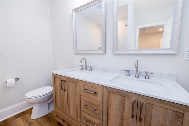 bathroom with hardwood / wood-style floors, vanity, and toilet