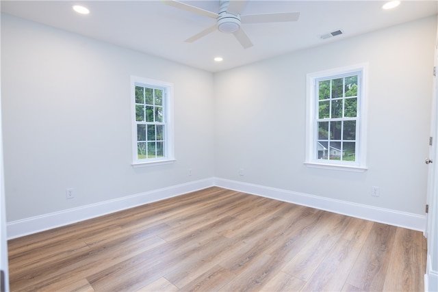 unfurnished room featuring ceiling fan, light wood-type flooring, and plenty of natural light