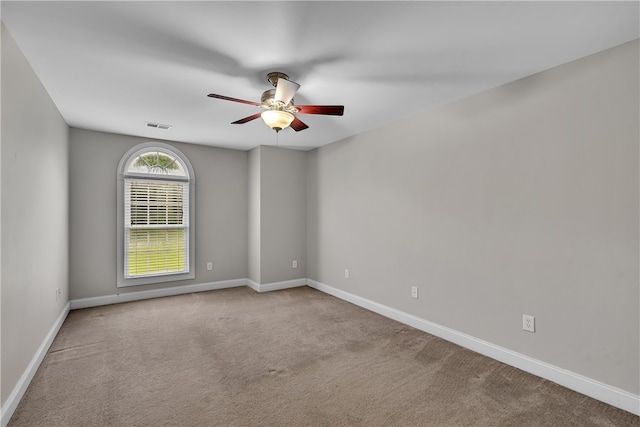 carpeted spare room featuring ceiling fan