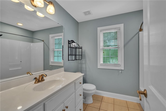 bathroom featuring walk in shower, vanity, toilet, and tile patterned floors