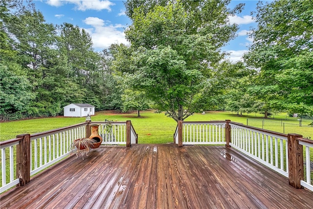 deck featuring a storage shed and a lawn