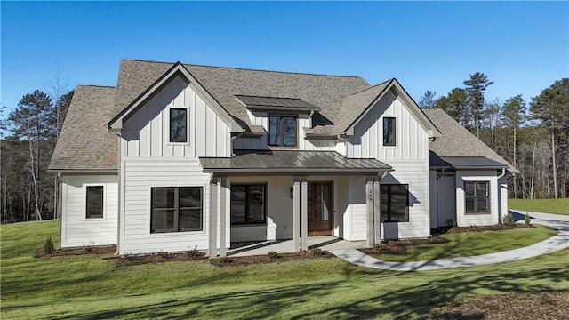 back of property with covered porch and a lawn