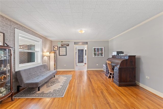 interior space featuring ornamental molding, light wood-type flooring, and brick wall