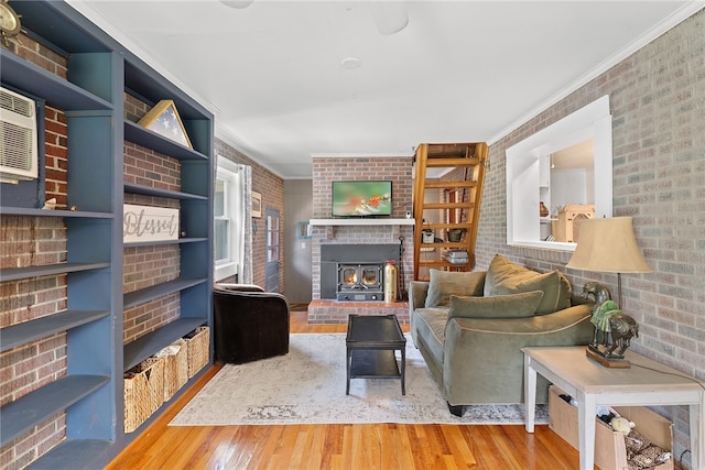 living room with ornamental molding, hardwood / wood-style floors, built in features, and brick wall