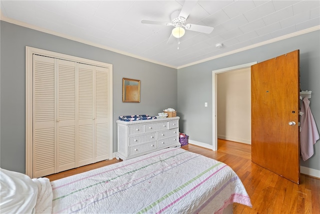 bedroom featuring ornamental molding, ceiling fan, a closet, and light hardwood / wood-style flooring