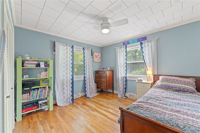 bedroom with ceiling fan, light hardwood / wood-style flooring, and crown molding