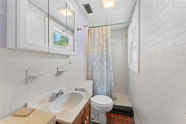 bathroom featuring tile walls, curtained shower, vanity, tile patterned flooring, and toilet