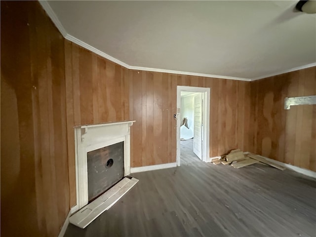 unfurnished living room with wooden walls, hardwood / wood-style floors, and crown molding