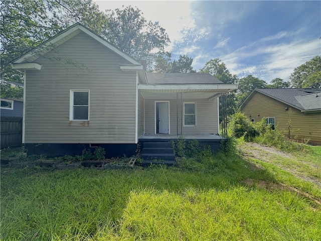 back of house featuring a lawn and a porch