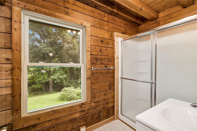 bathroom featuring wooden walls, beam ceiling, and a shower with shower door