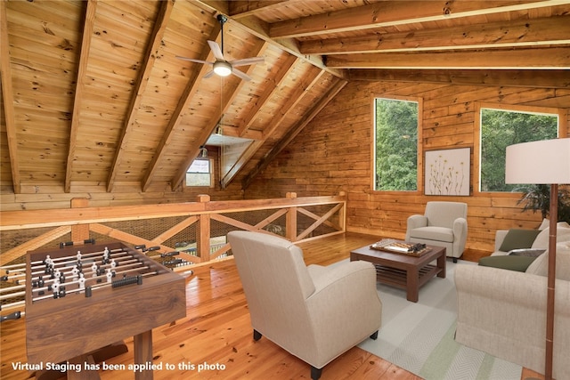 living area with wooden walls, plenty of natural light, and hardwood / wood-style floors