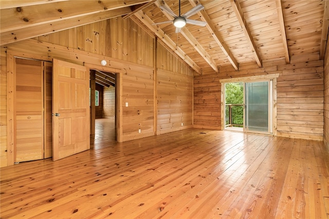 unfurnished living room with ceiling fan, wood walls, light hardwood / wood-style flooring, lofted ceiling with beams, and wooden ceiling