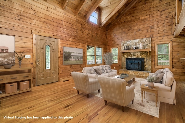 living room featuring beam ceiling, light hardwood / wood-style floors, high vaulted ceiling, and a healthy amount of sunlight