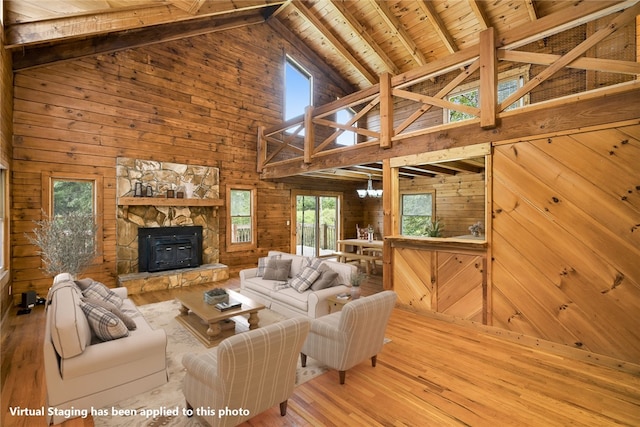 living room with high vaulted ceiling, hardwood / wood-style flooring, and a healthy amount of sunlight