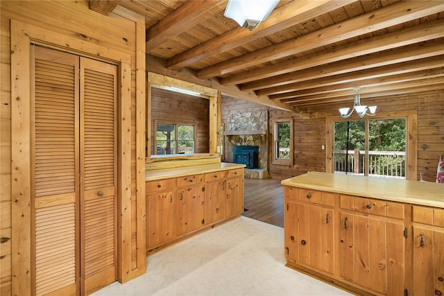 kitchen with a wealth of natural light, beam ceiling, and light colored carpet