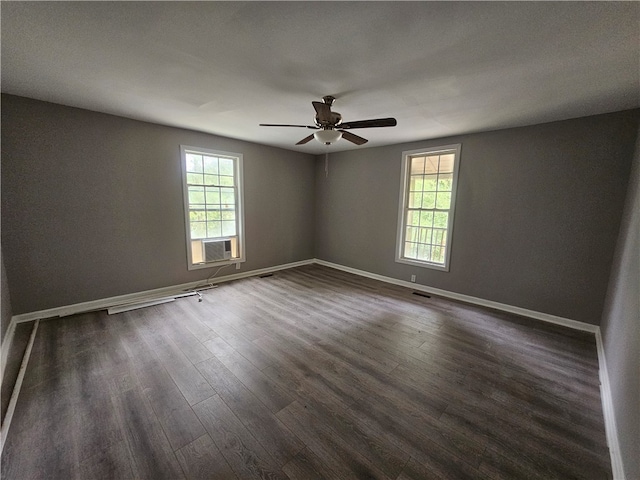 unfurnished room featuring a healthy amount of sunlight, ceiling fan, dark wood-type flooring, and cooling unit