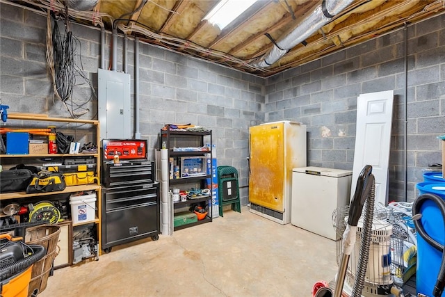 unfinished below grade area featuring fridge, electric panel, and concrete block wall