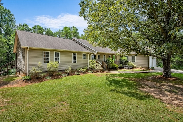 ranch-style home featuring a front yard and roof with shingles