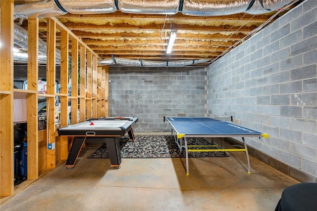 game room featuring concrete flooring and concrete block wall