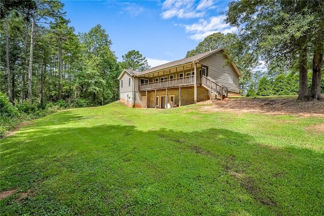 rear view of house with a deck and a yard