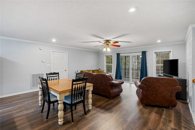 dining space with baseboards, visible vents, dark wood-style floors, a textured ceiling, and crown molding