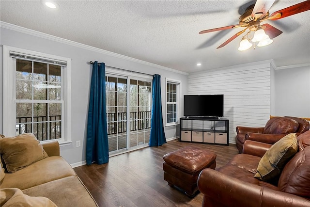 living area featuring a textured ceiling, a ceiling fan, baseboards, ornamental molding, and dark wood finished floors