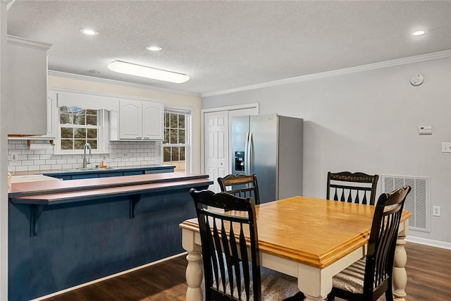 dining room featuring crown molding, visible vents, and dark wood-type flooring