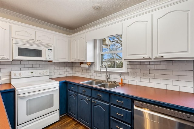 kitchen with white appliances, white cabinets, and a sink